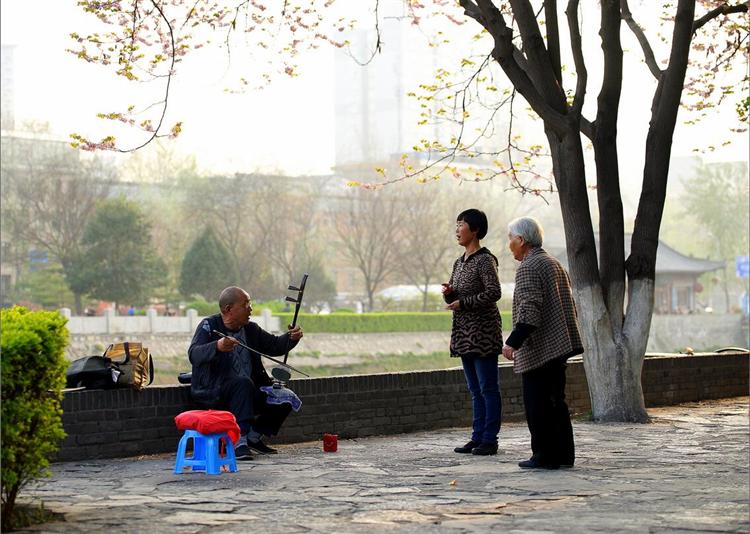 2015年3月30日，78岁的草师傅和他的学生正在辅导练习秦腔唱腔，这几年，草师傅在环城公园里前后辅导了几十名秦腔爱好者。